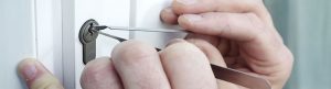 Cerrajero abriendo una cerradura de puerta con herramientas técnicas