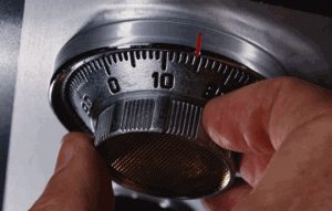 Mano ajustando el dial de combinación de una caja de fondos