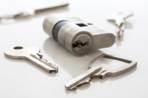 Cilindro de cerradura junto a dos llaves nuevas