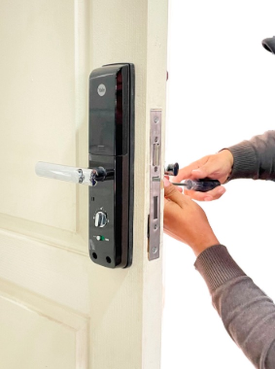 Técnico instalando una cerradura de seguridad en una puerta corporativa